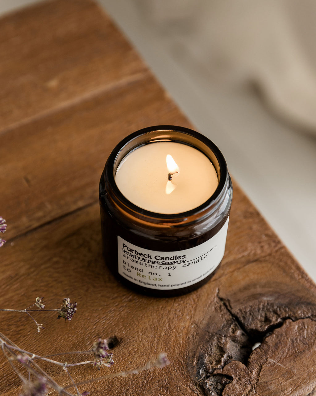 Purbeck Candles candle on a wooden surface with dried flowers
