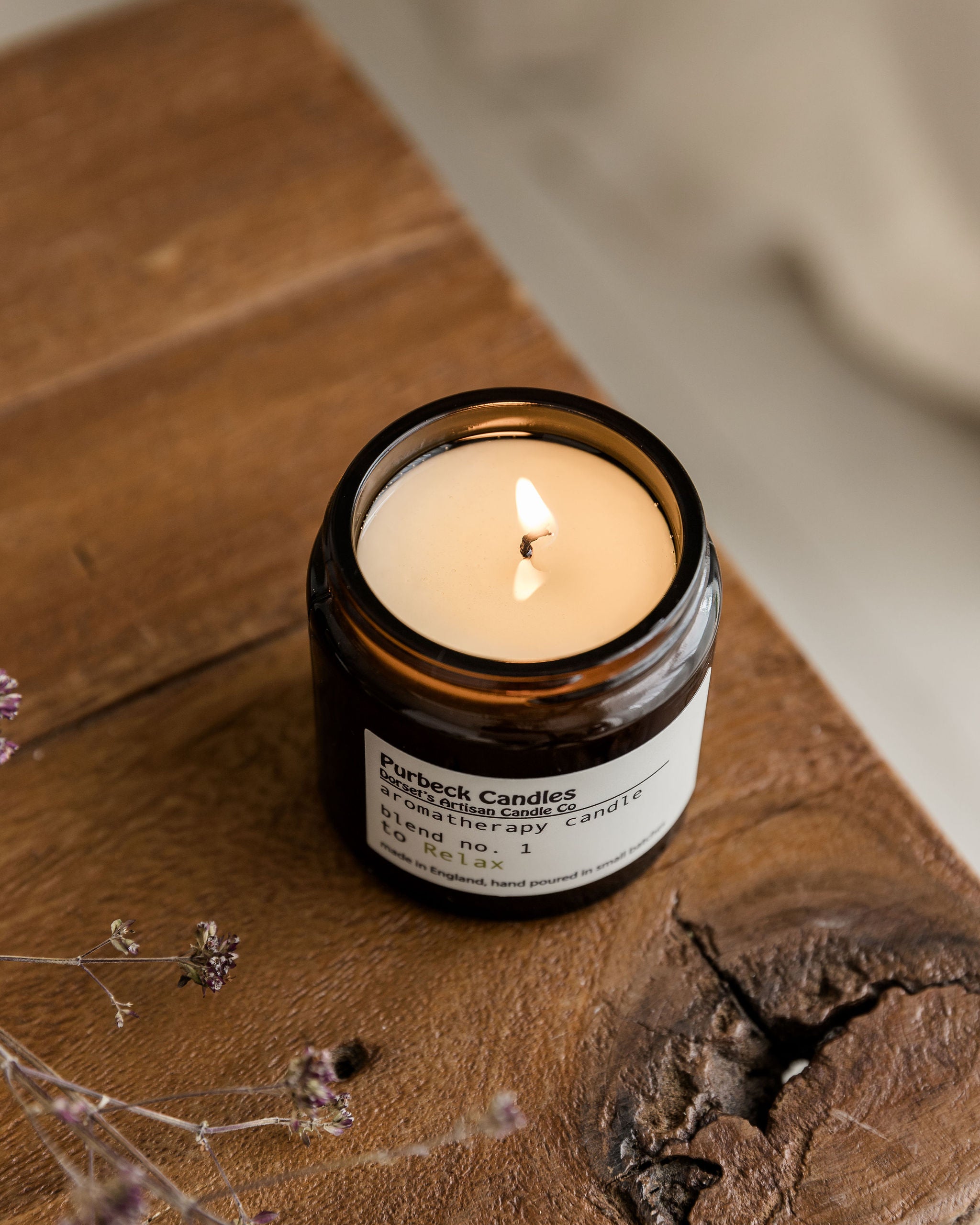 Purbeck Candles candle on a wooden surface with dried flowers