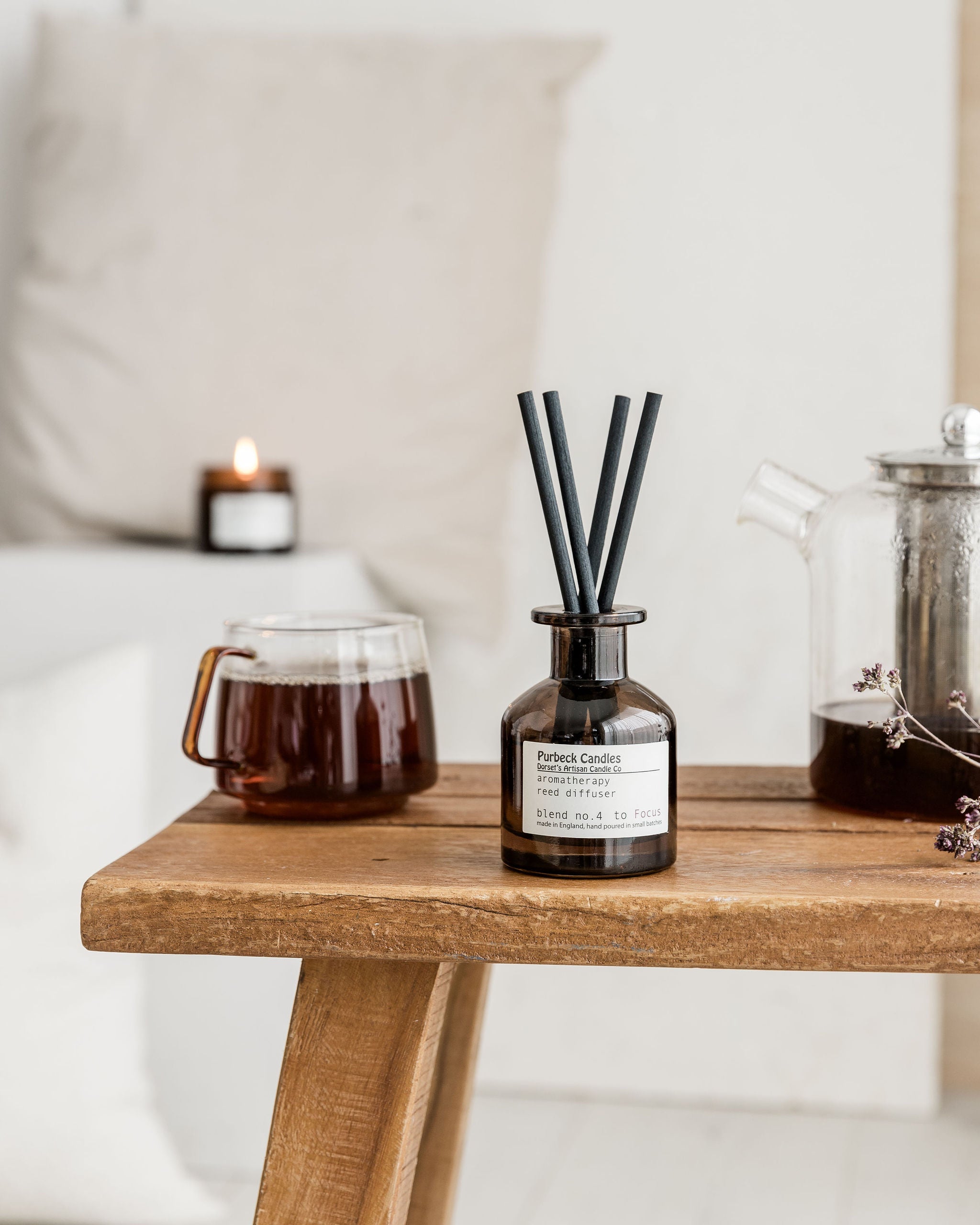 Diffuser with black sticks on a wooden table with a blurred background