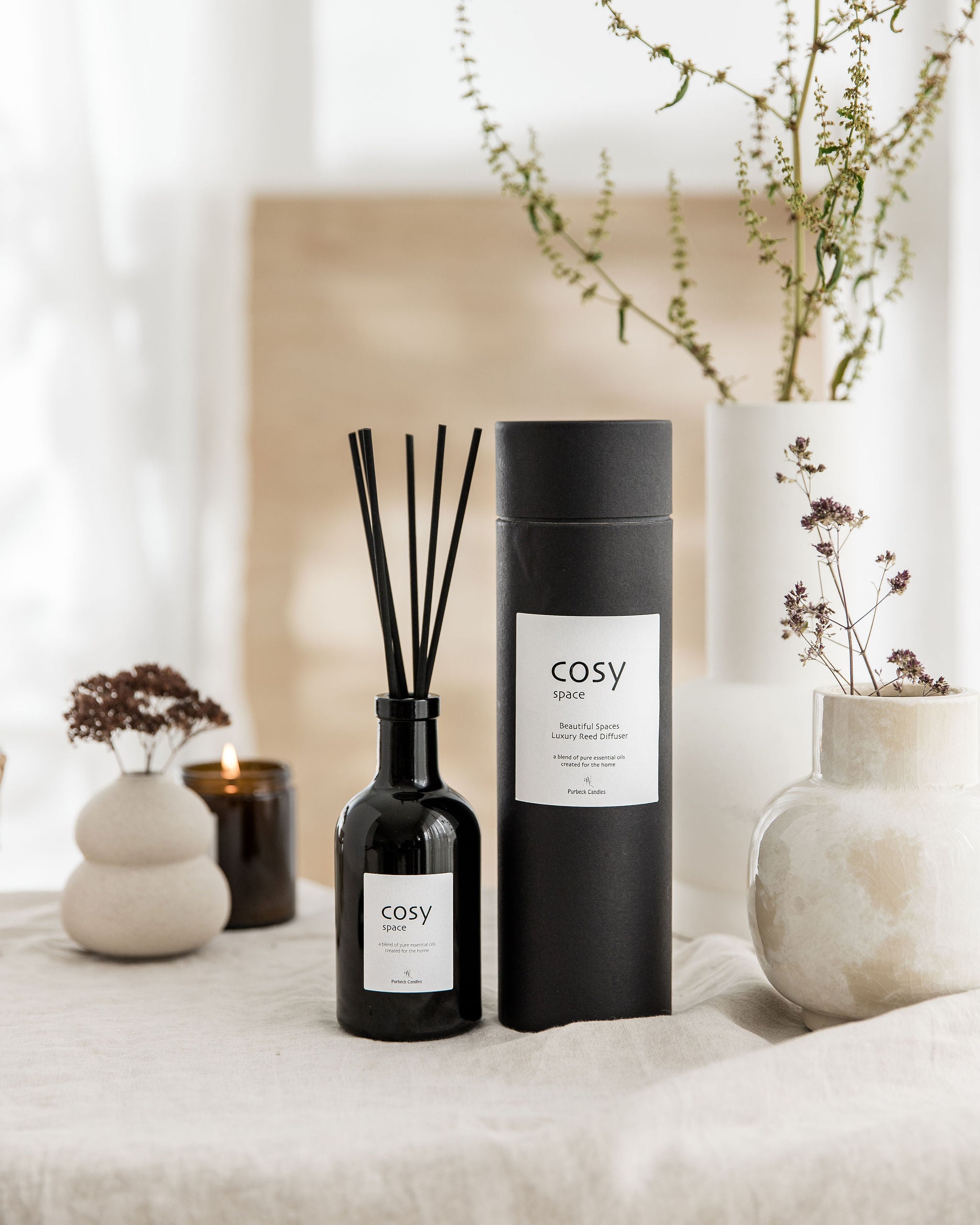 Cosy diffuser bottle and packaging on a neutral background