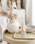 Diffuser bottle with reeds on a table with decorative elements