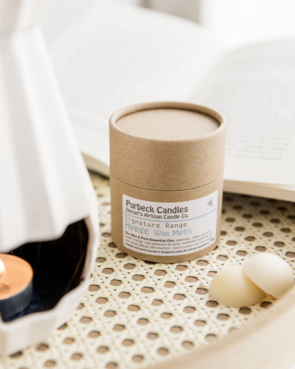 Candle in a cardboard tube with 'Purbeck Candles' label on a textured surface