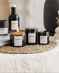 Collection of 'pamper' branded products including candles and bottles on a textured surface.