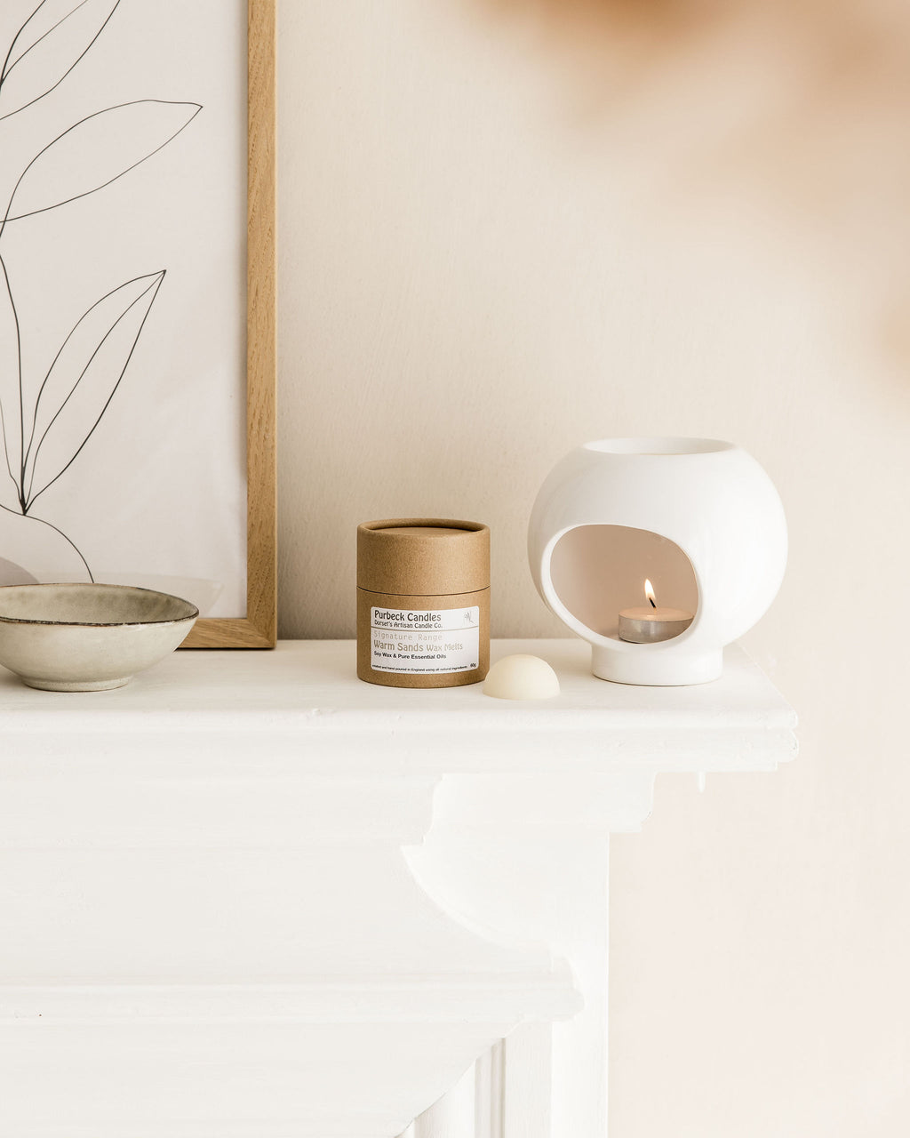 Candle and candle holder on a white surface with a neutral background