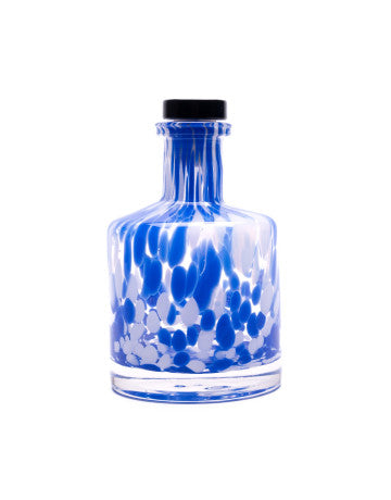 Glass bottle with blue and white marbled design and black cap on a white background