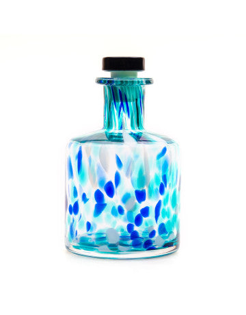 Decorative glass bottle with blue abstract design on a white background