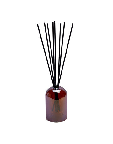 Reed diffuser with black sticks in a brown bottle on a white background