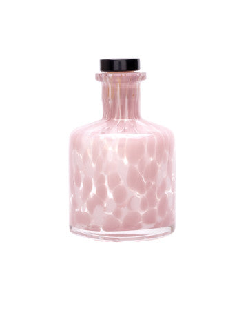 Pink glass bottle with black cap on a white background